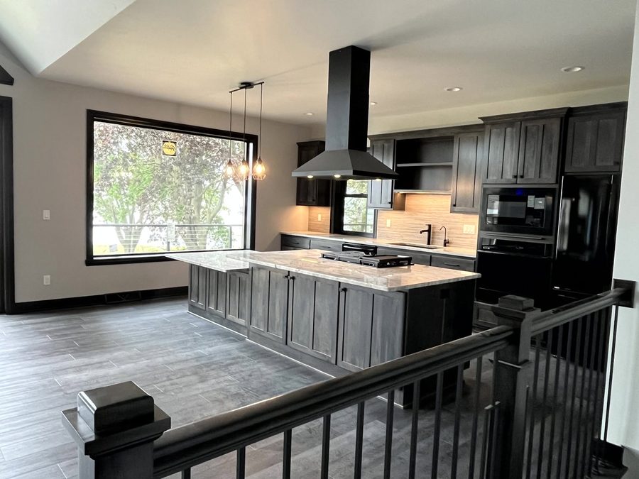 Kitchen with dark cabinets and a black range hood