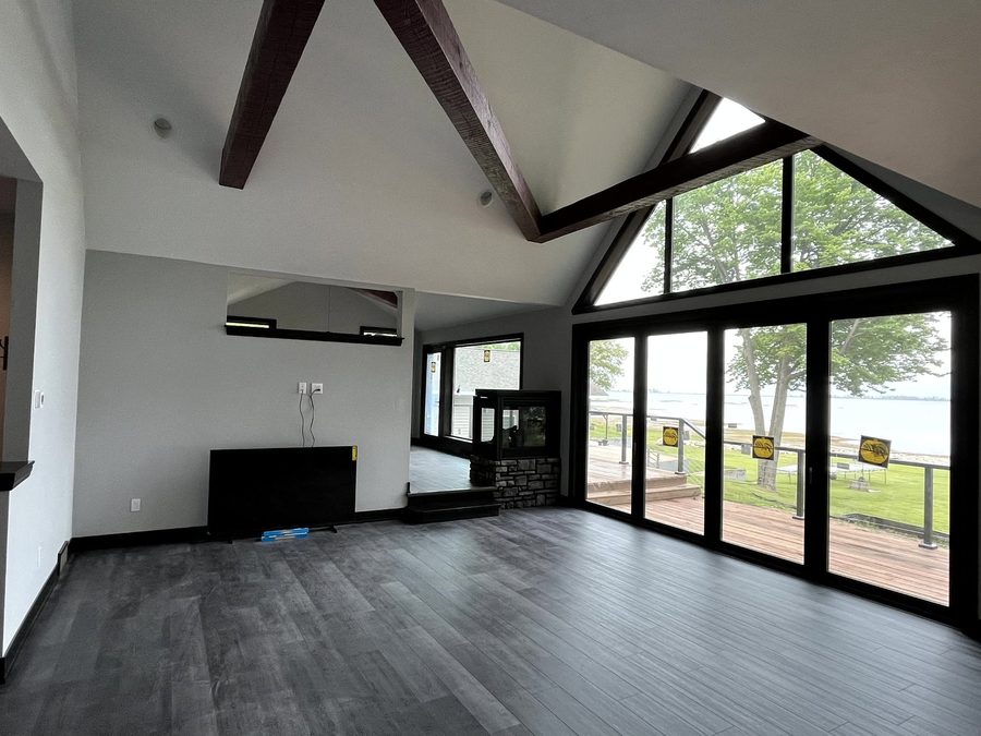 Vaulted great room with a wall of windows to the water