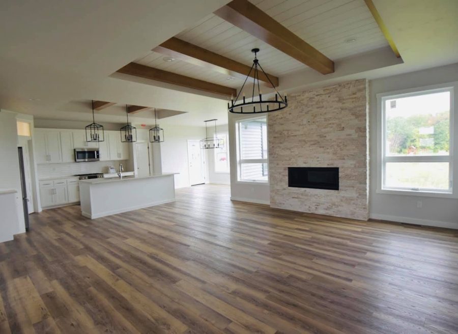 Great room with a beamed ceiling and a stone fireplace